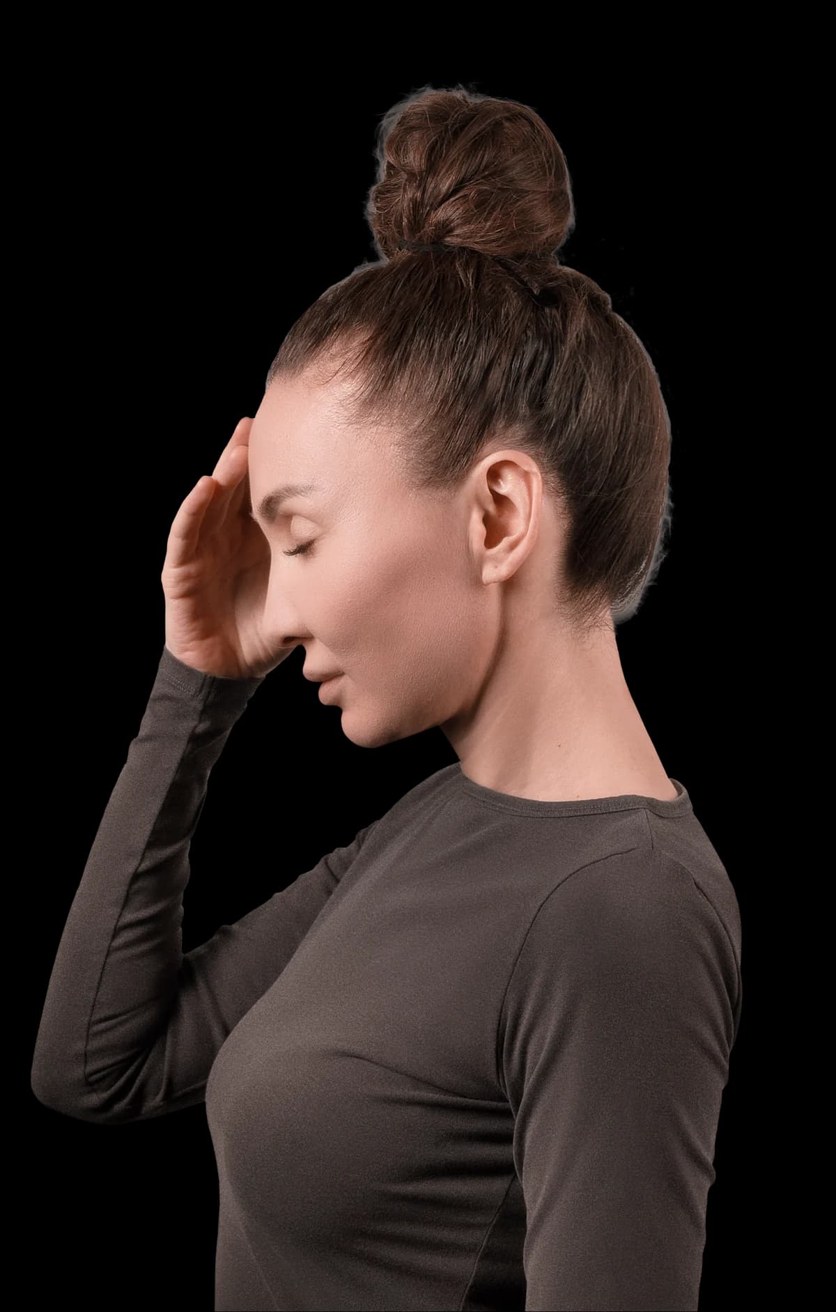 A woman with her eyes closed holding her head, standing in for the autopilot state